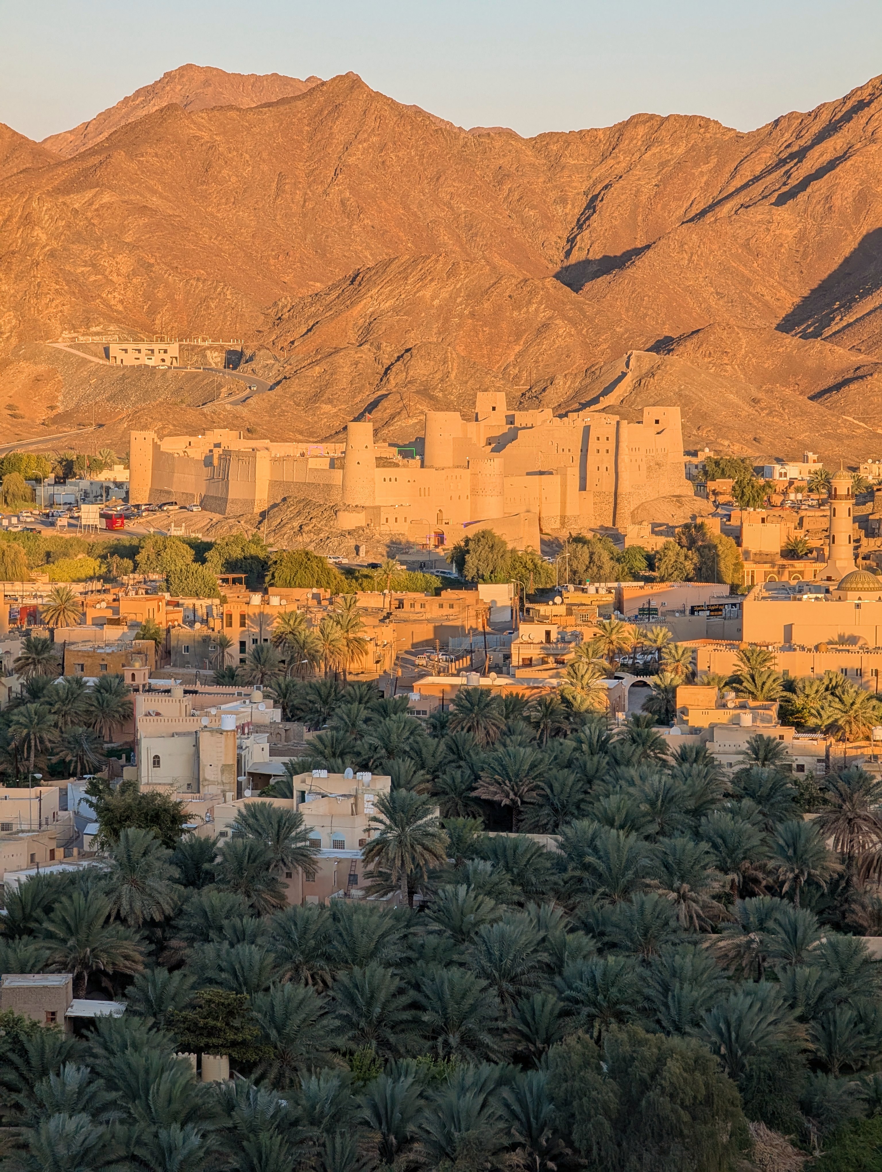 Bahla Fort from Bahla Top View at sunset with orange mountains and palms